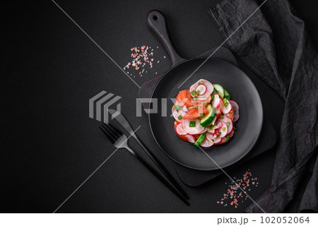 Delicious vegan salad of fresh vegetables of tomatoes, cucumbers and radishes 102052064
