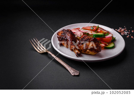 Delicious nutritious dish consisting of grilled chicken legs with a salad 102052085