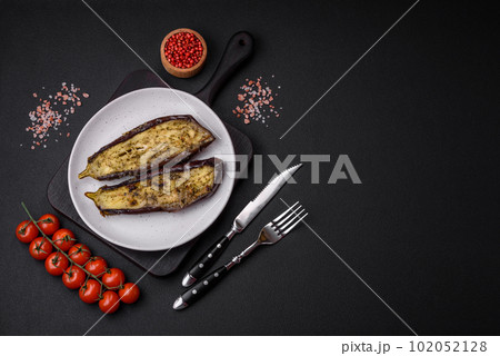 Delicious eggplant cut into two halves baked with salt, spices and herbs 102052128