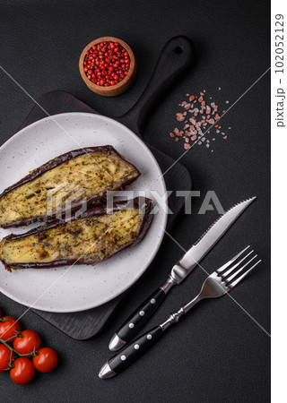 Delicious eggplant cut into two halves baked with salt, spices and herbs 102052129