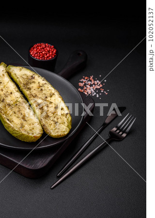 Delicious zucchini cut into two halves baked with salt, spices and herbs 102052137