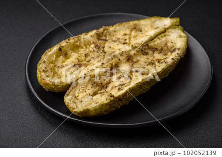 Delicious zucchini cut into two halves baked with salt, spices and herbs Delicious zucchini cut into two halves baked with salt, spices and herbs 102052139