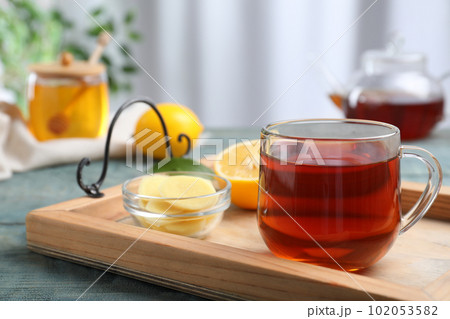 Delicious tea with honey, ginger and lemon on tray 102053582