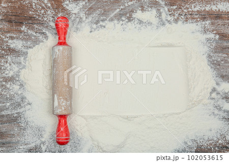Flour and rolling pin on wooden table, top view. Space for text Flour and rolling pin on wooden table, top view. Space for text 102053615
