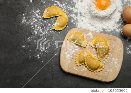 Flat lay composition with raw ravioli on grey table. Italian pasta 102053662