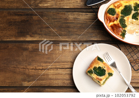 Tasty broccoli casserole served on wooden table, flat lay. Space for text 102053792