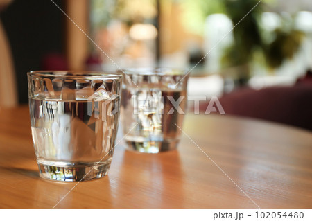 Glasses of water on wooden table in cafe. Space for text 102054480