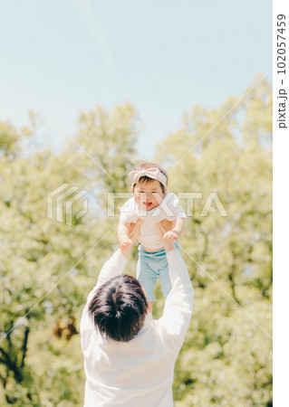 高い高いをしているパパと女の子のファミリー写真 高い高いをしているパパと女の子のファミリー写真 102057459