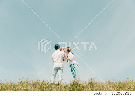 土手沿いに立っている家族 102067310