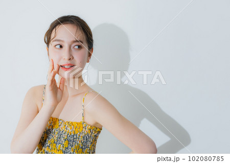 麦わら帽子を持っている女性 102080785