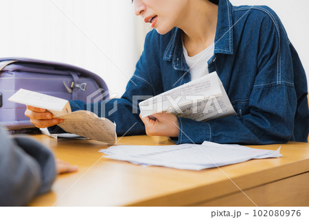 リビングでお便りを読む小学生とお母さん リビングでお便りを読む小学生とお母さん 102080976