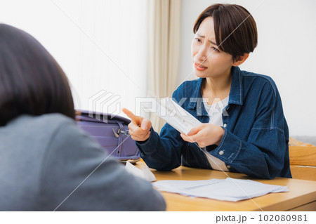 リビングでお便りを読む小学生とお母さん　 102080981