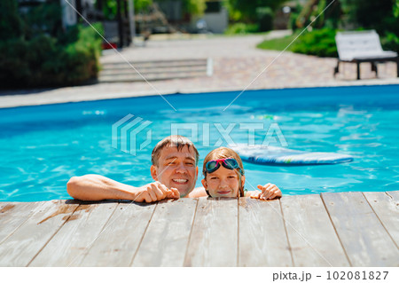 Dad and daughter have fun and swim at the edge...の写真素材