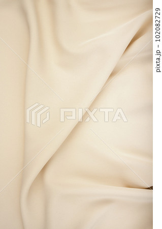 The texture of the satin fabric of beige color for the background 102082729