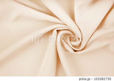 The texture of the satin fabric of beige color for the background 102082730