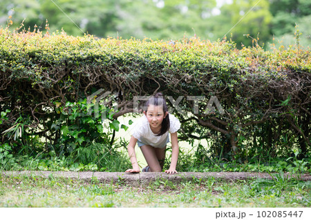 植木の抜け道を通る子供 102085447