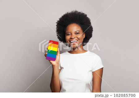 African american woman with phone with LGBT flag screen. Support, stop discrimination African american woman with phone with LGBT flag screen. Support, stop discrimination 102085700