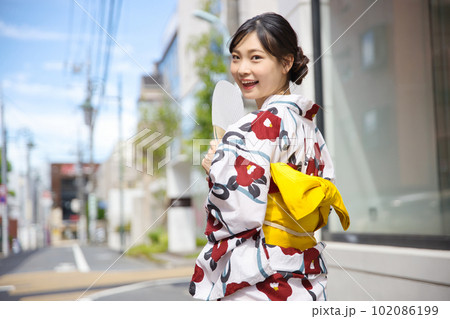 浴衣姿で街を歩く若い女性の後ろ姿 浴衣姿で街を歩く若い女性の後ろ姿 102086199