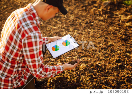 Hand of expert farmer collect soil and checking soil health before growth a seed of vegetable. 102090198
