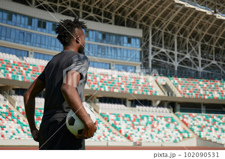 African-American soccer player on training drill. Legs of footballer running on grass practice field African-American soccer player on training drill. Legs of footballer running on grass practice field 102090531
