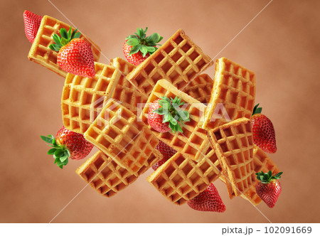 Belgian waffles with fresh strawberries in motion. 102091669