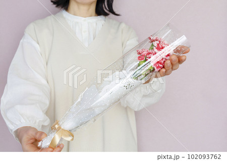 花束を持つ女性　淡いピンク背景 102093762