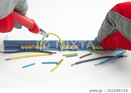 Cutting the electrical cable jumper on the terminal block with wire cutters 102096548