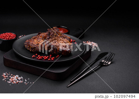Delicious beef or pork steak on the bone grilled with spices and rosemary Delicious beef or pork steak on the bone grilled with spices and rosemary 102097494