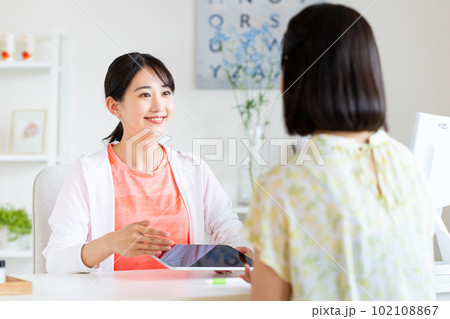 ジムの受付をする若い女性 102108867