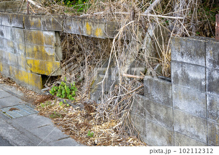 崩れたコンクリートブロックの塀 102112312