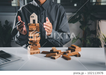 Hands stop domino effect before destroy home before fail, Hand of engineer man protection blocks wood tower, business risk and strategy dangerous project, Insurance concept Hands stop domino effect before destroy home before fail, Hand of engineer man protection blocks wood tower, business risk and strategy dangerous project, Insurance concept 102113976