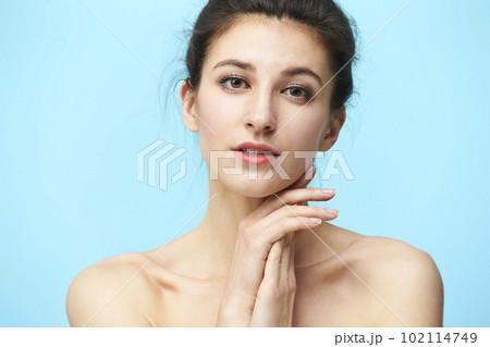 head and shoulder portrait of a young caucasian woman isolated on blue background 102114749