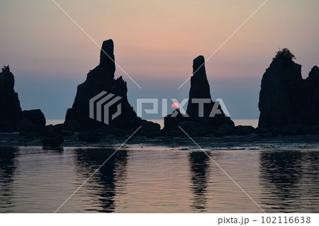 早朝の海岸に立つ奇岩 102116638