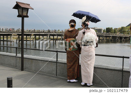 川沿いを歩く2人連れの後ろ姿 102117479