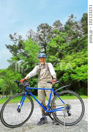 藤の花をバックに自転車にまたがる 102118251