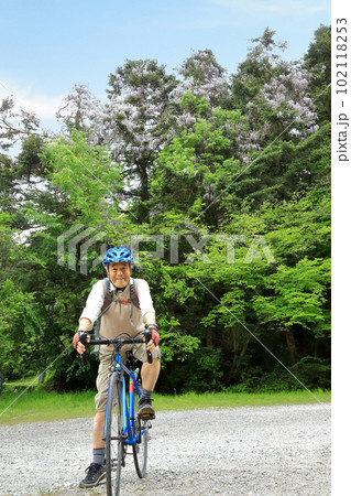 藤の花をバックに自転車にまたがる 102118253