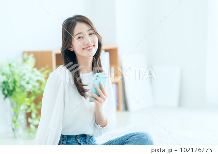 リビングでスマホを操作する若い女性 リビングでスマホを操作する若い女性 102126275