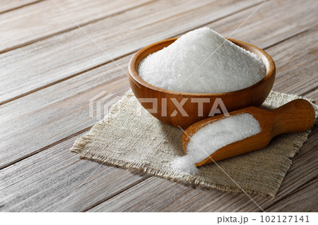 white sugar in bowl and in scoop on table 102127141
