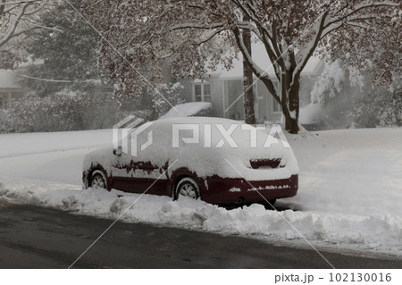 Car covered in snow in a street after a snow storm 102130016