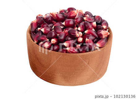 Purple corn seeds in wooden bowl isolated on white background with full depth of field 102130136