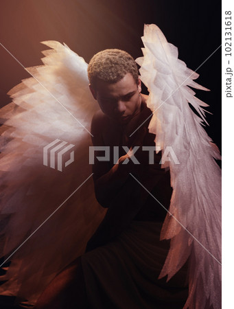 Young strong angel with white wings from heaven. Angel with muscular body. Sensual man 102131618
