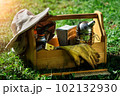 Beekeeping equipment. A tool of the beekeeper. Everything for a beekeeper to work with bees. Smoker, a chisel, a box, beekeeper suit for protection from the bees. Photo on the topic of beekeeping. 102132930