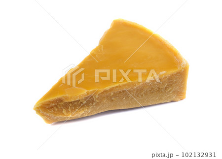 A piece of natural beeswax on a white background. A piece of natural beeswax on a white background. 102132931