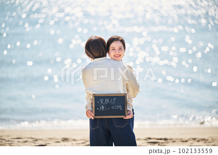 海でブラックボードを持つ若い女性と友達 海でブラックボードを持つ若い女性と友達 102133559
