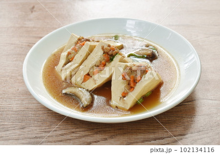 steamed white tofu stuffed mashed pork in gravy sauce on plate 102134116