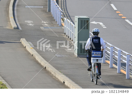 ヘルメットをかぶって自転車に乗る警察官 ヘルメットをかぶって自転車に乗る警察官 102134849
