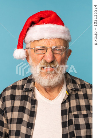 Gloomy angry Santa Claus portrait against blue background. Economy crisis and troubles end of year concept 102135524