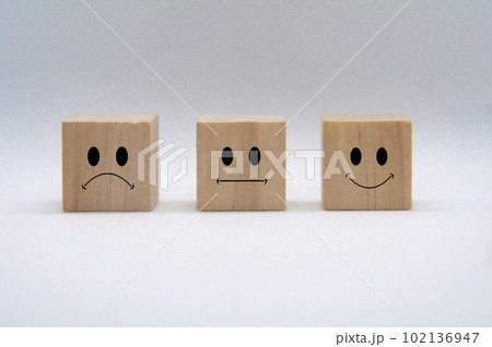 Sad, neutral and happy emoticon faces on wooden cubes with white background cover. Customer feedback, satisfaction and evaluation concept 102136947