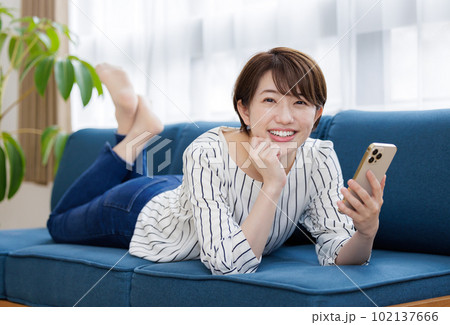 ソファでスマホを操作する女性 ソファでスマホを操作する女性 102137666