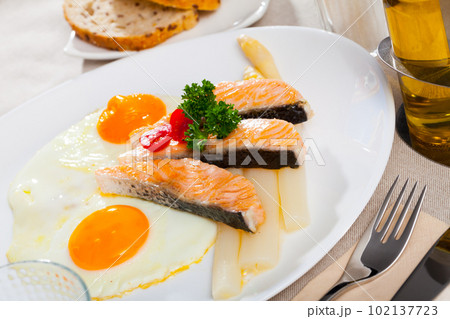 Delicious grilled salmon with eggs, tomatoes, asparagus and parsley 102137723